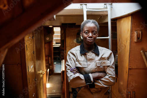Foto Moody waist up portrait of black young woman standing with arms crossed in boat