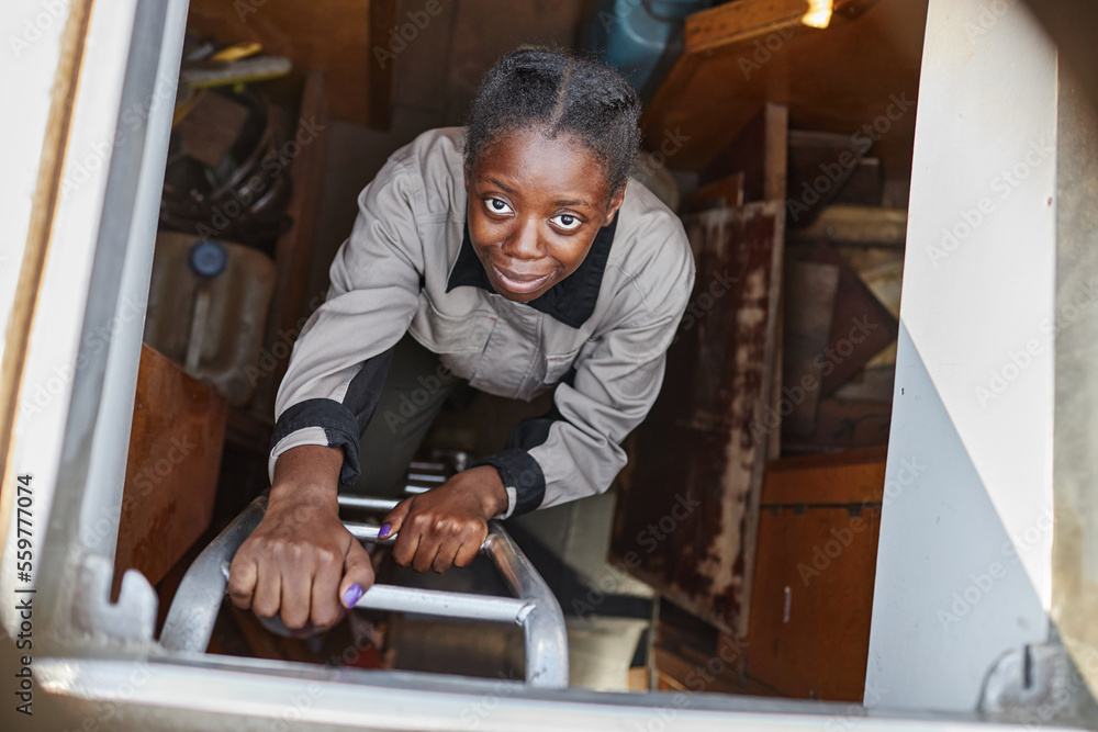 Top view portrait of young woman climbing ladder in boat and looking at camera Top view portrait of young woman climbing ladder in boat and looking at camera
