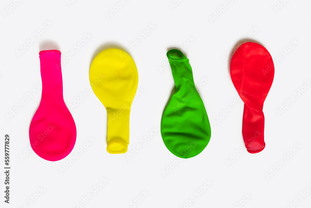 Multi-colored non-inflated balloons on a white background. Balloons for decoration for the holidays in a deflated state. Four airless latex balloons Multi-colored non-inflated balloons on a white background. Balloons for decoration for the holidays in a deflated state. Four airless latex balloons