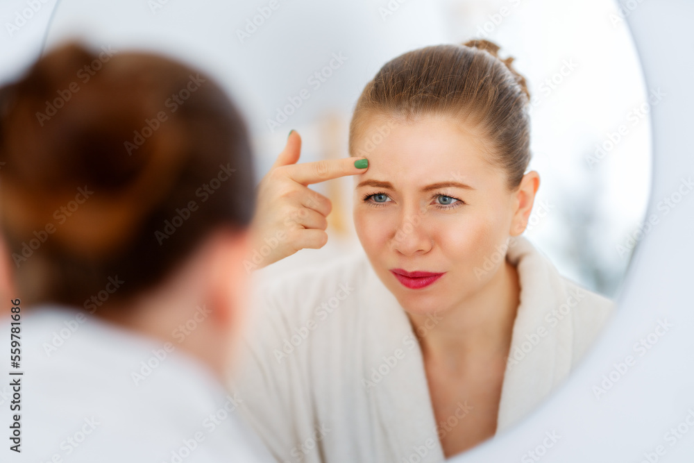 woman looking at wrinkles woman looking at wrinkles