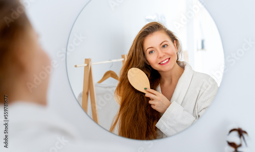 woman brushing her red hair photo