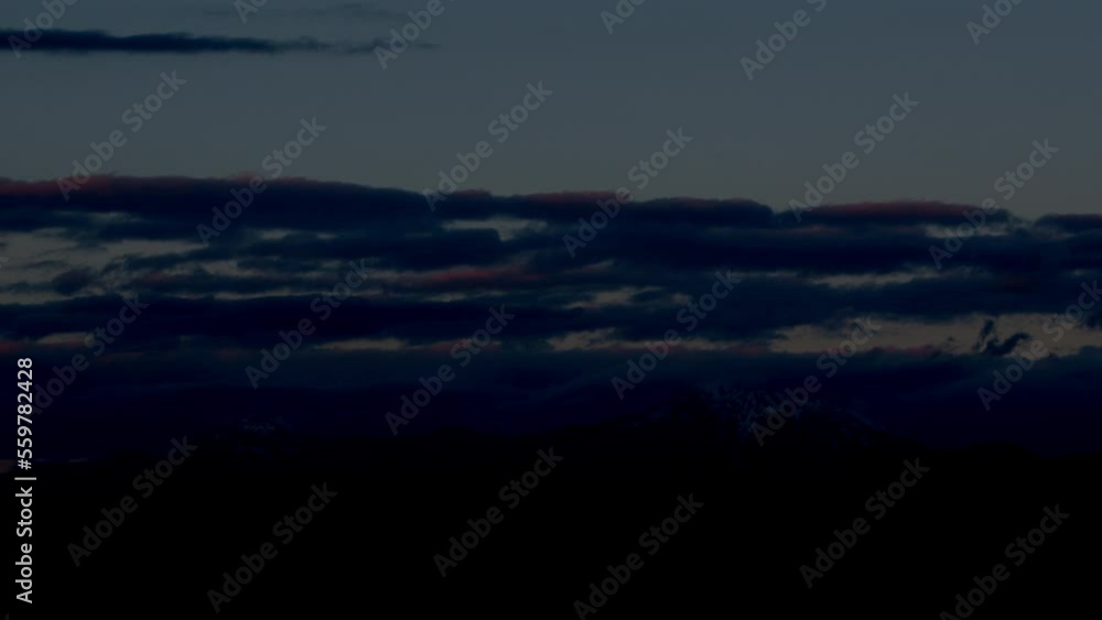 Sunset clouds over snowy peaks. Mesmerizing sky in the mountain landscape. Going black Sunset clouds over snowy peaks. Mesmerizing sky in the mountain landscape. Going black