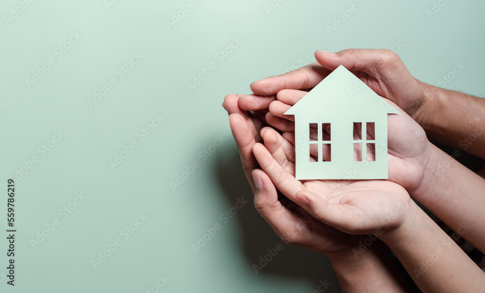 Hands holding wooden house, family home, homeless housing, mortgage crisis and home protecting insurance, international day of families, foster home care, family day care, stay home concept - obrazy, fototapety, plakaty 