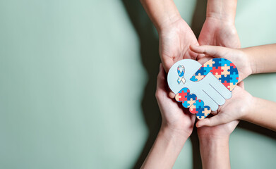 Father, Mother, Children holding heart jigsaw puzzle, Color puzzle symbol of awareness for autism spectrum disorder family support. Autism World Awareness Day.