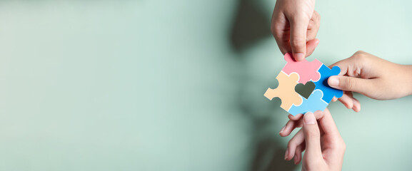 Color puzzle symbol of awareness for autism spectrum disorder family support. Father, Mother, Children holding jigsaw puzzle Autism World Awareness Day.