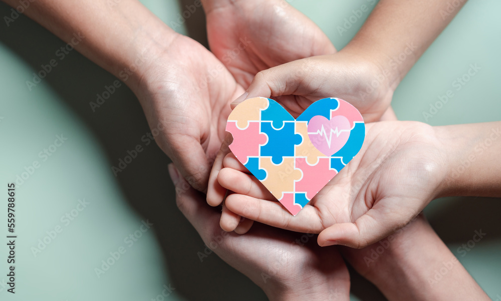 Father, Mother, Children holding heart jigsaw puzzle, Color puzzle symbol of awareness for autism spectrum disorder family support. Autism World Awareness Day. Father, Mother, Children holding heart jigsaw puzzle, Color puzzle symbol of awareness for autism spectrum disorder family support. Autism World Awareness Day.