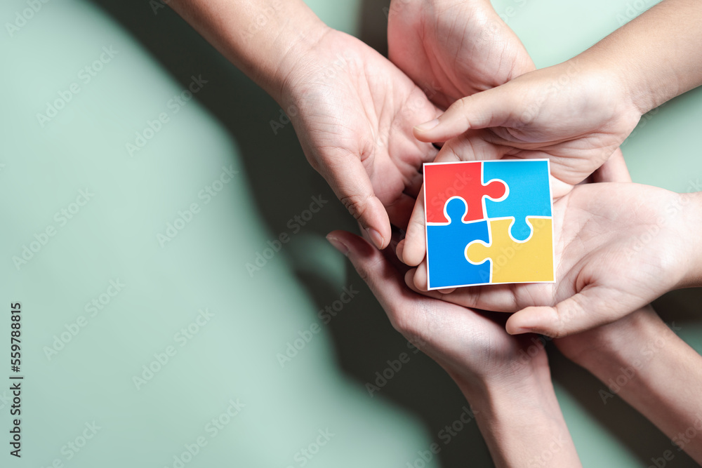Color puzzle symbol of awareness for autism spectrum disorder family support. Father, Mother, Children holding jigsaw puzzle Autism World Awareness Day.
