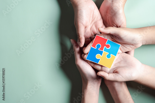 Wallpaper Mural Color puzzle symbol of awareness for autism spectrum disorder family support. Father, Mother, Children holding jigsaw puzzle Autism World Awareness Day. Torontodigital.ca