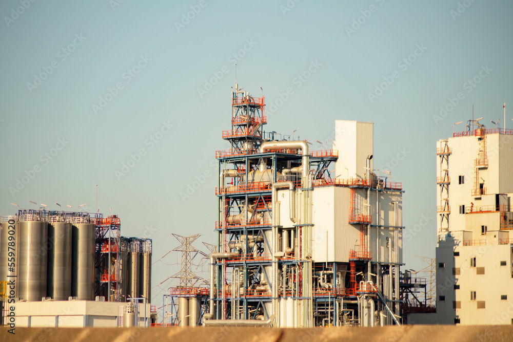 constructions, buildings, towers, chimneys, pipelines at a petrochemical plant in focus and out of focus, in selective focus, industrial view of the factory area