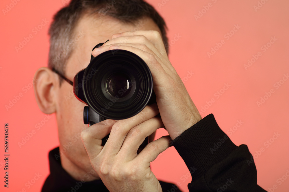 a young person takes a photo with a digital SLR camera with an old lens