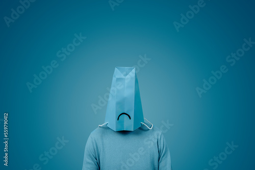 man wears a blue bag with a sad face in his head photo