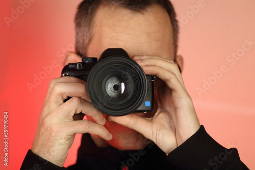 a young person takes a photo with a digital SLR camera with an old lens