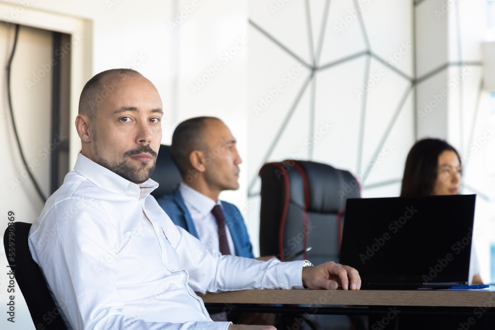 Business portrait of a male professional manager at a meeting with colleagues in a conference room