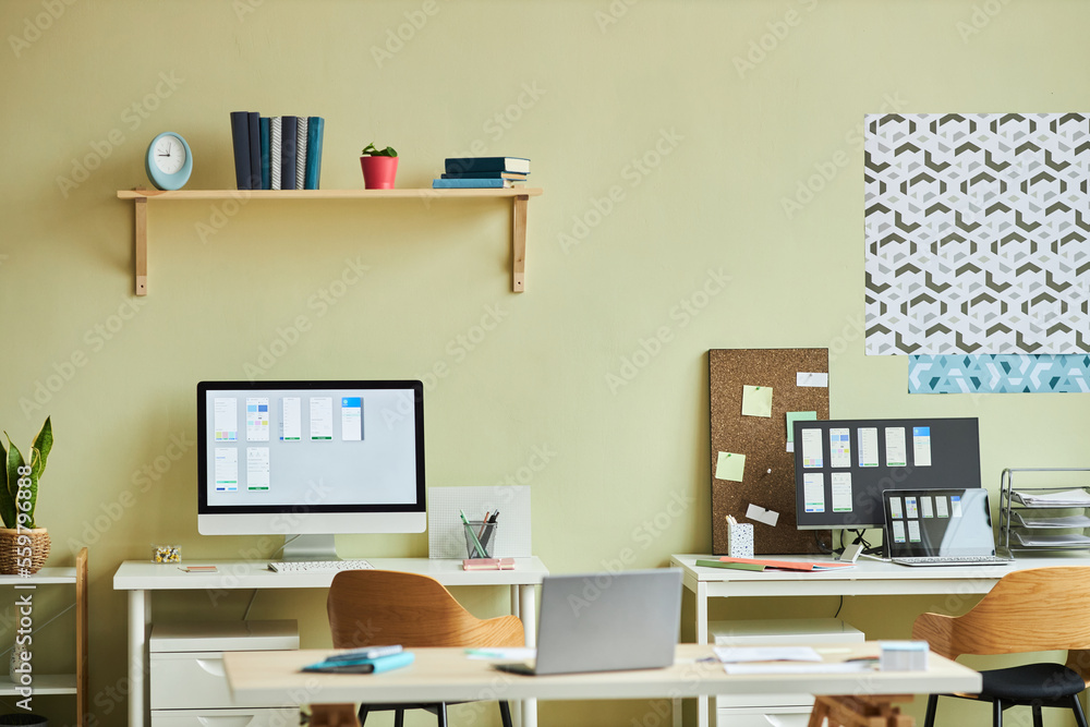 Background image of minimal office interior with computers on desks and pastel yellow wall, copy space Background image of minimal office interior with computers on desks and pastel yellow wall, copy space