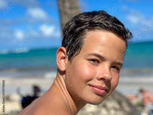 Young boy is enjoying on the beautiful tropical beach at summer, close up portrait