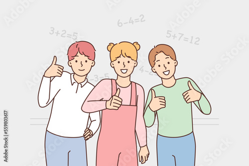 Smiling schoolchildren show thumb up