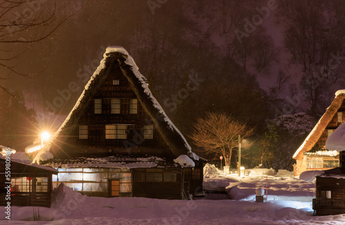 Traditional A-frame house in Gokayama amid snow and mist at night photo