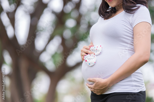 Portrait of asian Beautiful pregnant woman at the park,Thailand people,Happy woman concept,Her use hand touch her belly,Mother day concept