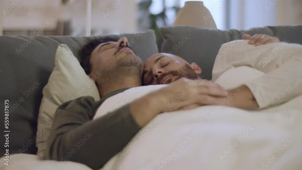 Homosexual men hugging while sleeping in bed in morning. Close-up shot of bearded Caucasian gay couple relaxing on weekends, spending time together at home. Sleep cycle, love, LGBT concept Homosexual men hugging while sleeping in bed in morning. Close-up shot of bearded Caucasian gay couple relaxing on weekends, spending time together at home. Sleep cycle, love, LGBT concept