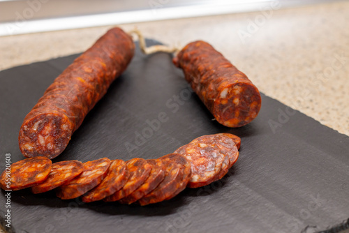 Authentic chorizo ​​from León cut into thin slices, presented on a slate stone, made with different Iberian pork meats