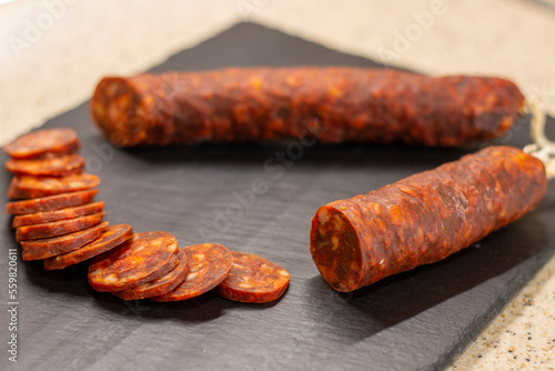 Authentic chorizo ​​from León cut into thin slices, presented on a slate stone, made with different Iberian pork meats