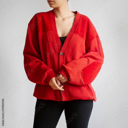 Woman wearing red oversized cardigan and black jeans isolated on white background