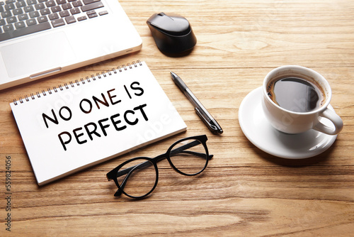 No One Is Perfect, motivational words and sentences for work and life. Quote sentence in notebook with laptop, pen, coffee over wooden background.