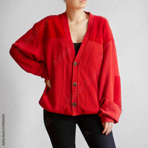 Woman wearing red oversized cardigan and black jeans isolated on white background