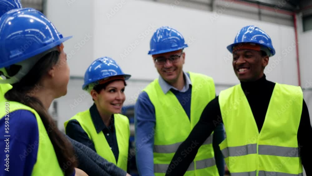 Happy multiracial engineer stacking hands while working at robotics warehouse - Industry concept Happy multiracial engineer stacking hands while working at robotics warehouse - Industry concept