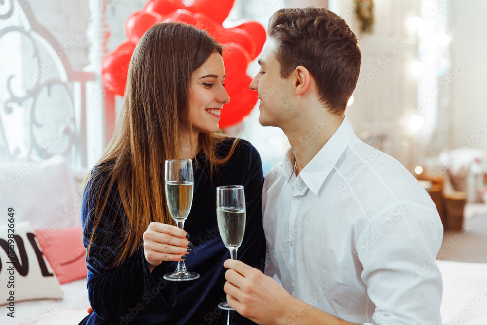 Couple in love celebrating Saint Valentine's day. They hugging, smiling and drinking champagne. Concept of happy Valentine's day. Women's day. Couple in love celebrating Saint Valentine's day. They hugging, smiling and drinking champagne. Concept of happy Valentine's day. Women's day.