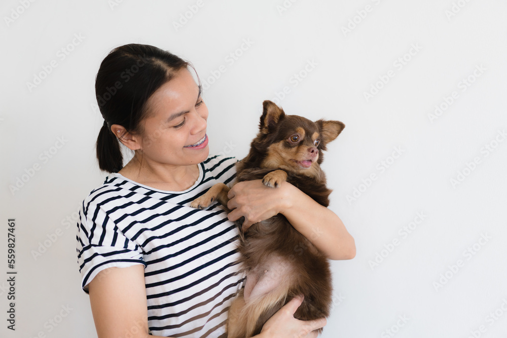 young woman hugging and showing some love to his puppy at home , isolate white background . Female pet lover with domestic animal young woman hugging and showing some love to his puppy at home , isolate white background . Female pet lover with domestic animal