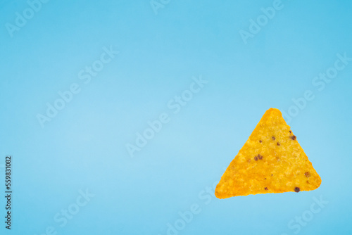 nachos chips isolated on blue background. falling down doritos triangle