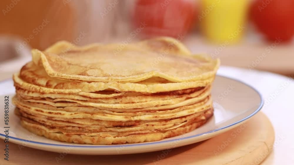 Freshly baked hot pancakes stacked in a stack. Cooking crepes, thin crepes with raised steam for morning breakfast Freshly baked hot pancakes stacked in a stack. Cooking crepes, thin crepes with raised steam for morning breakfast