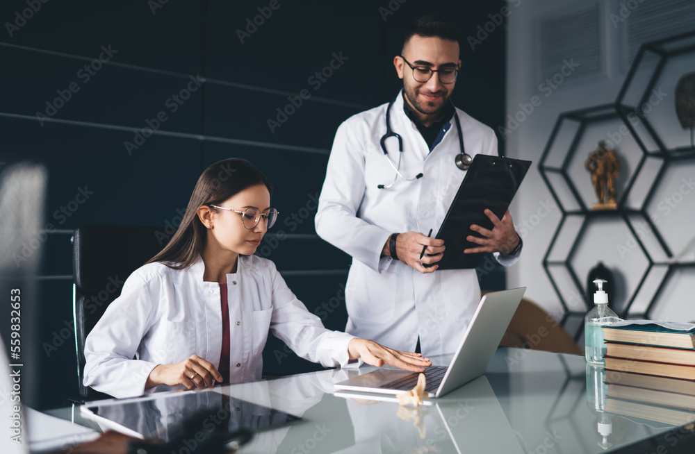 Medical specialists working on laptop in office Medical specialists working on laptop in office