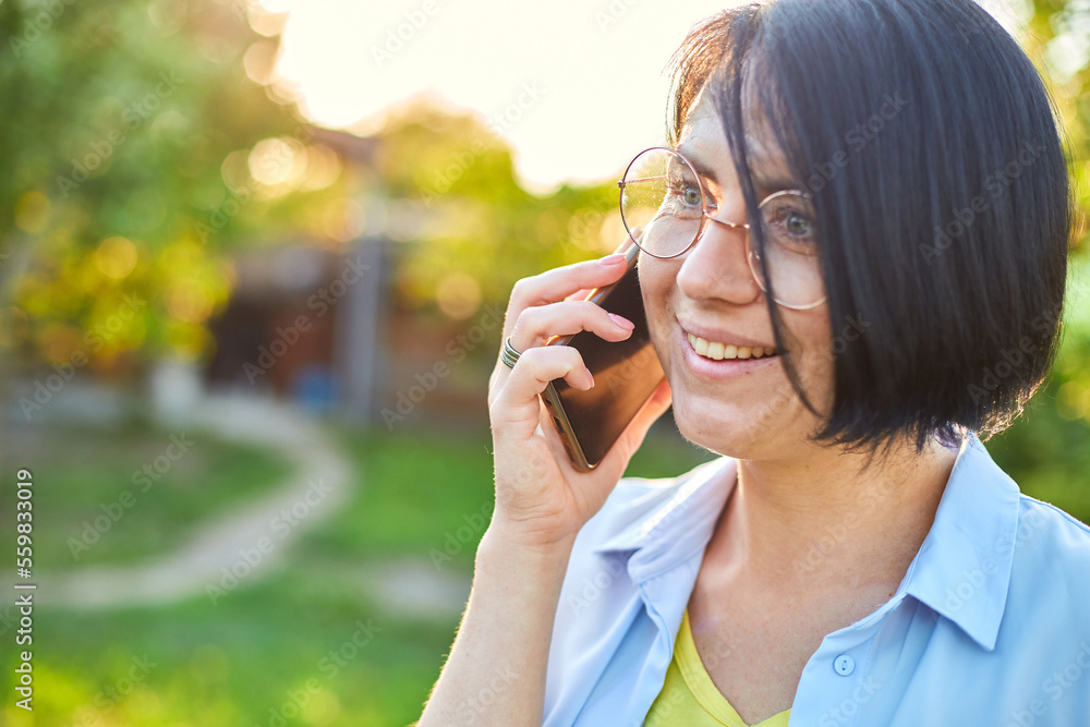 Happy woman in glasses talking on mobile phone outdoor, Happy woman in glasses talking on mobile phone outdoor,