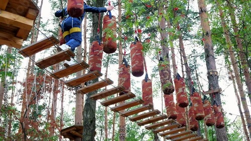 Rope adventure park, high school student on track in mountain helmet and protective gear.