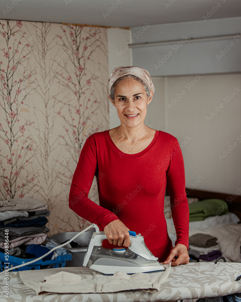 Smiling elderly woman ironing pants Smiling elderly woman ironing pants