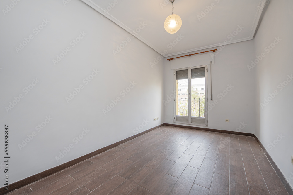 Obraz premium Empty room with dark wood-like stoneware floors and exit to a terrace with aluminum and glass double doors