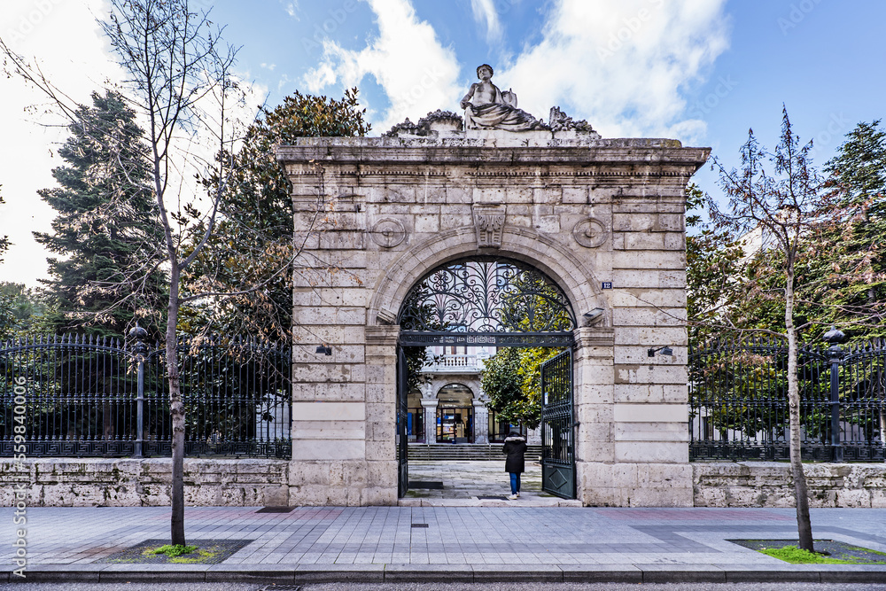Obraz premium Monumental stone door of a metal wrought iron fence at the entrance to a farm with a small palace inside