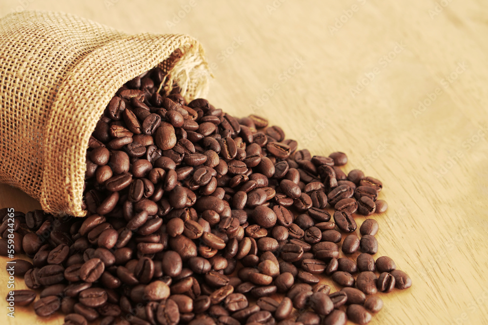 Sack of coffee beans on wooden background Sack of coffee beans on wooden background