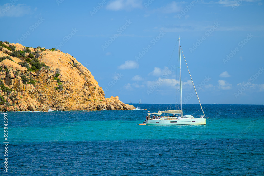 A yacht moored by the beach in Sardinia on a sunny day