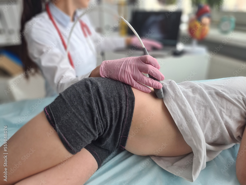 Naklejka premium Medical examination of little girl using ultrasound equipment of liver kidneys