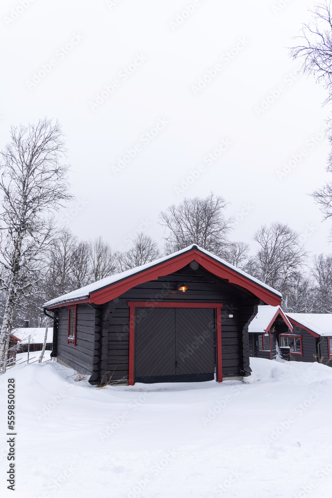 Beautiful little wooden mountain houses, huts surrounded by forest on a sunny winter day. Skiing resort in Sweden, Funasdalen covered in snow