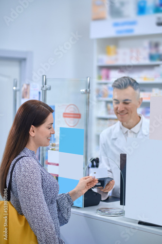 Long-haired woman buying medicines at the drugstore