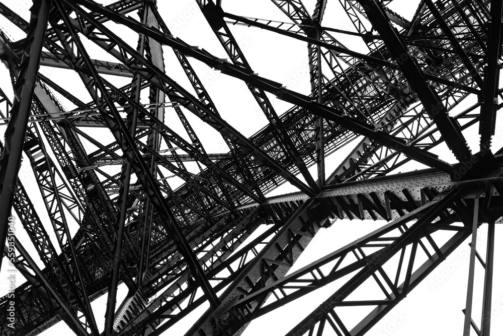Steel construction of the very high historical railway Bridge “Müngstener Brücke“ between Solingen and Remscheid Germany from below the railroad track. Frog perspective black and white greyscale.