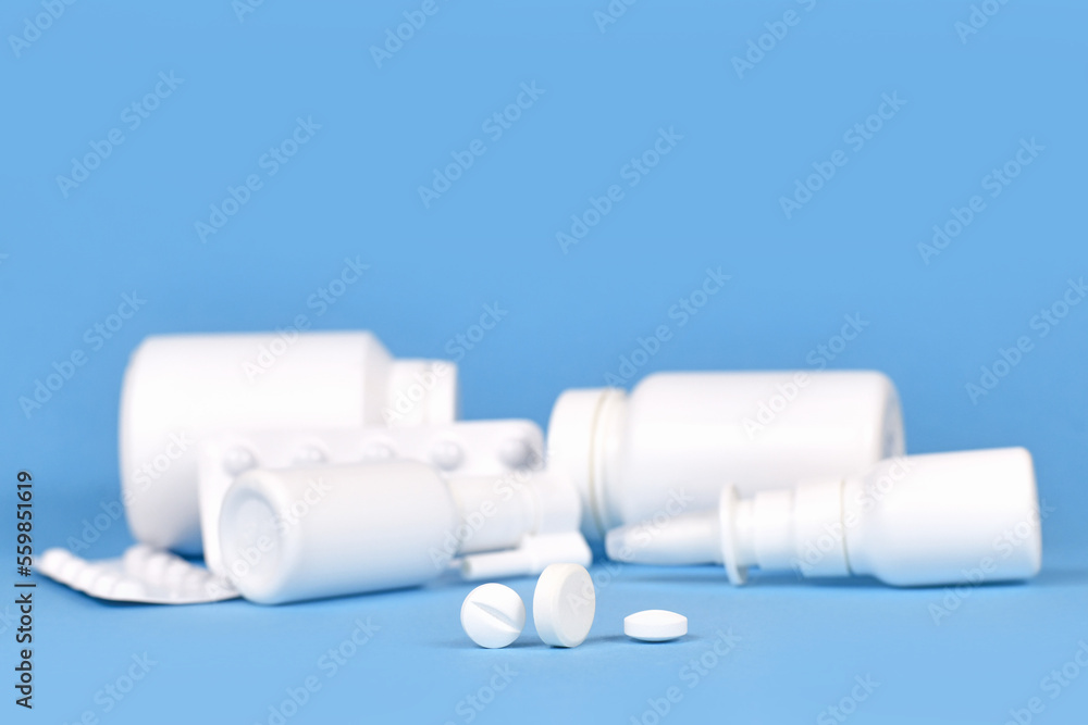 Pills with medication for cold and flue in blurry blue background
