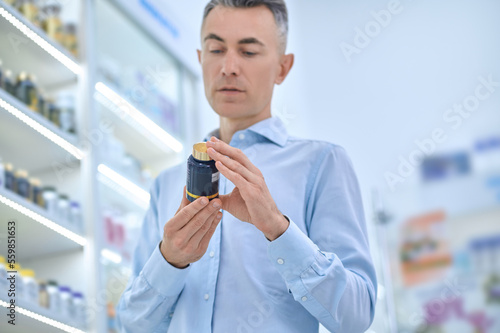 Mid aged man choosing supplements at the drugstore