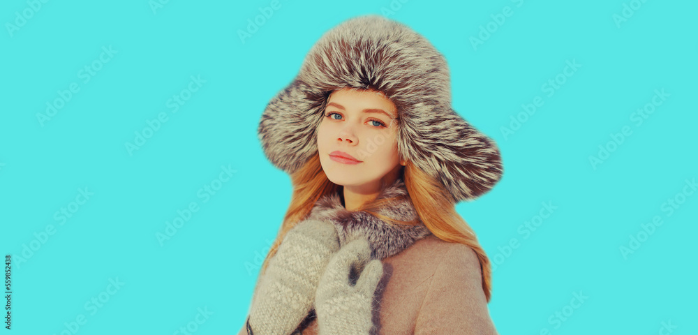 Portrait of beautiful young blonde woman in winter hat on blue background Portrait of beautiful young blonde woman in winter hat on blue background