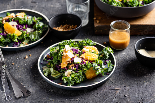 Red cabbage, kale, orange, parmesan and walnuts salad. Dark backround.  photo