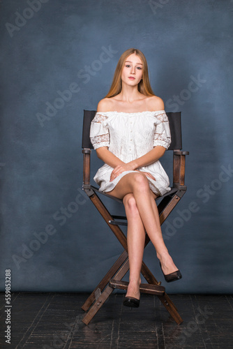 Full body portrait of a young beautiful blonde model in white dress © Andrey_Arkusha